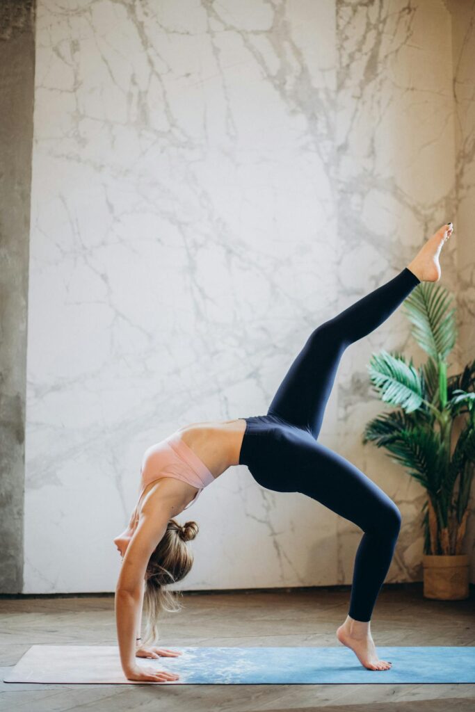 Une femme réalisant une posture de Pilates fusion.