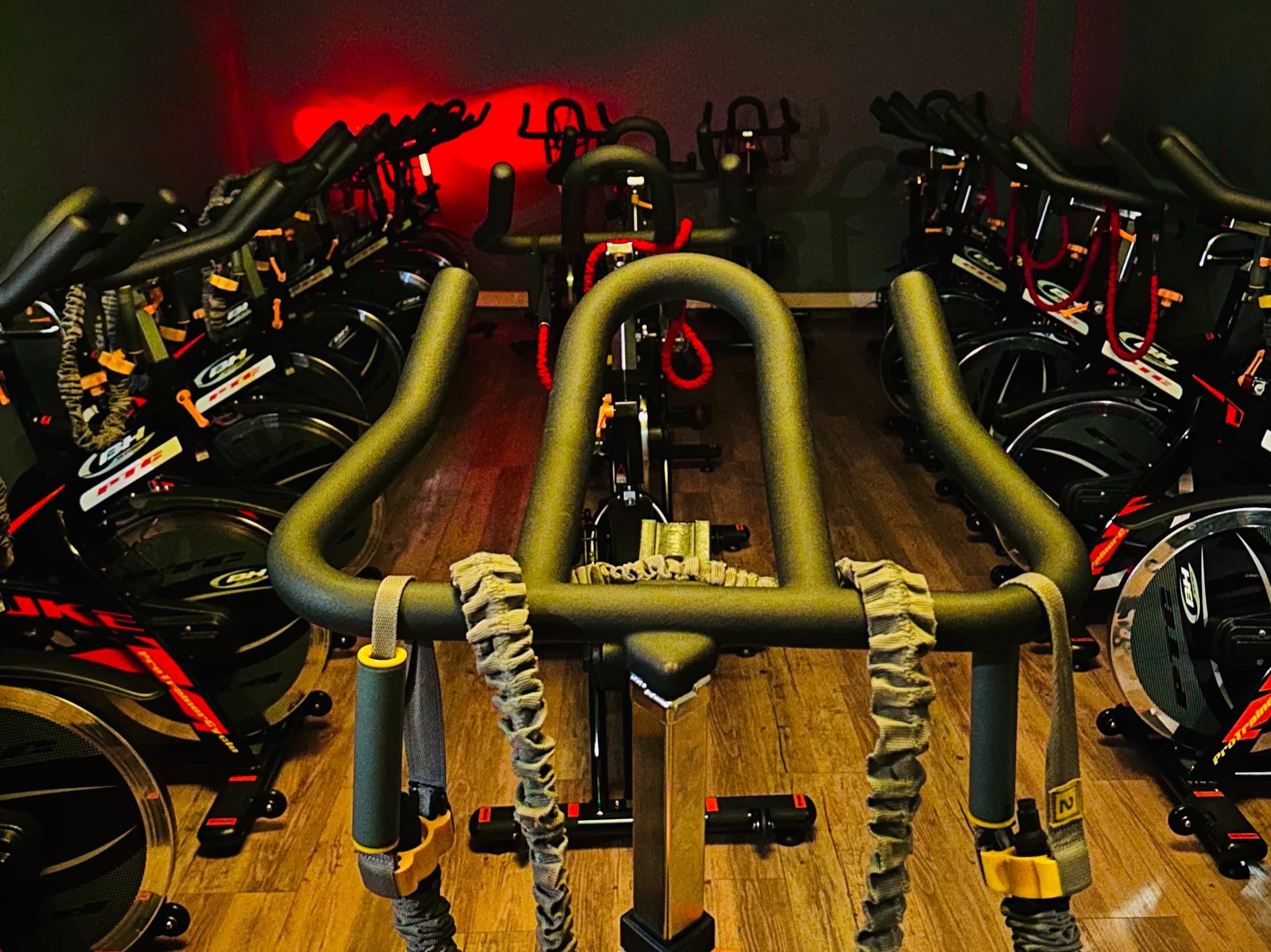 Cours de biking collectif chez Glam Fitness, avec des vélos et une ambiance animée.