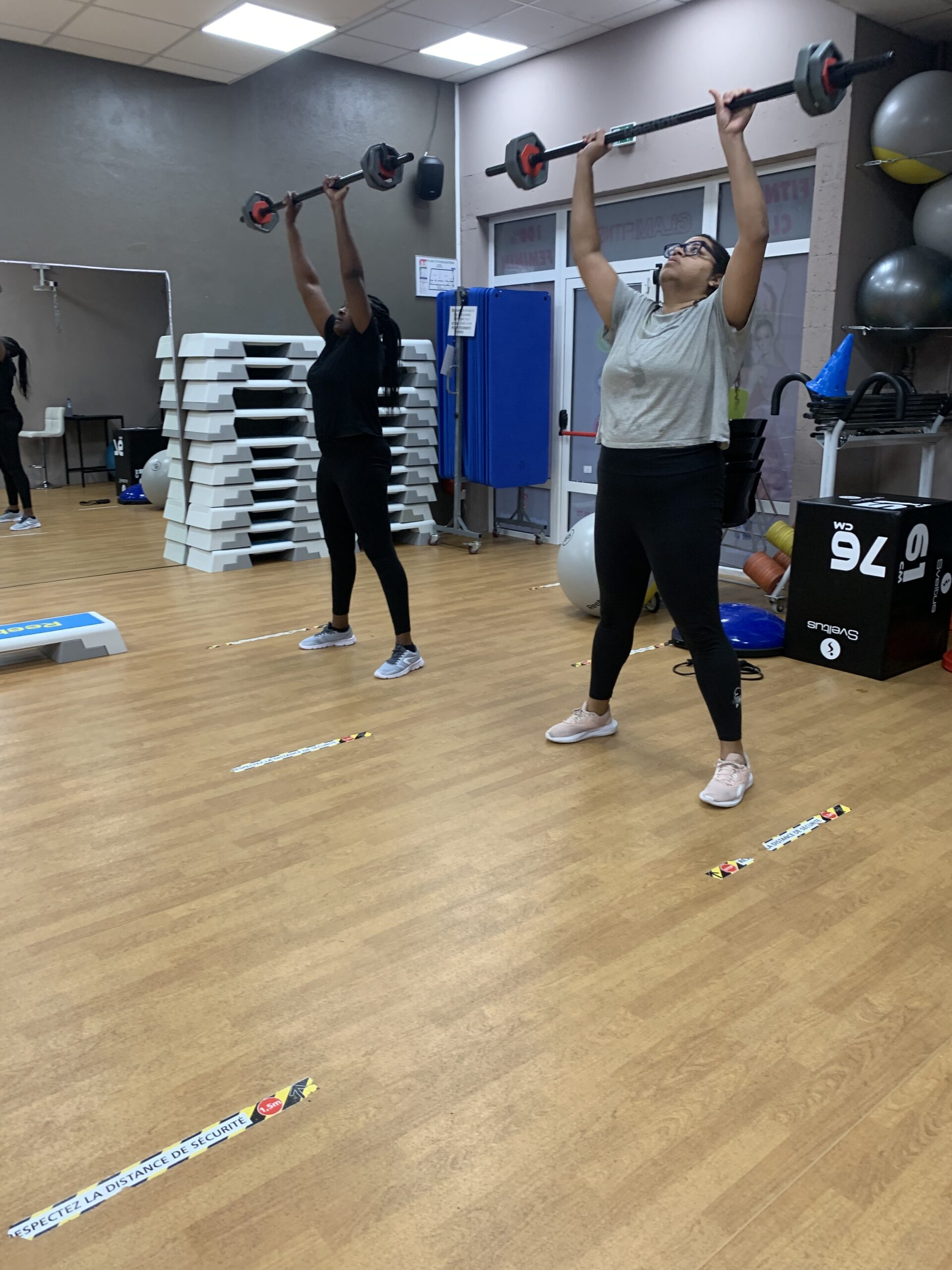 Deux femmes soulèvent une barre de musculation chargée pendant un cours de circuit training